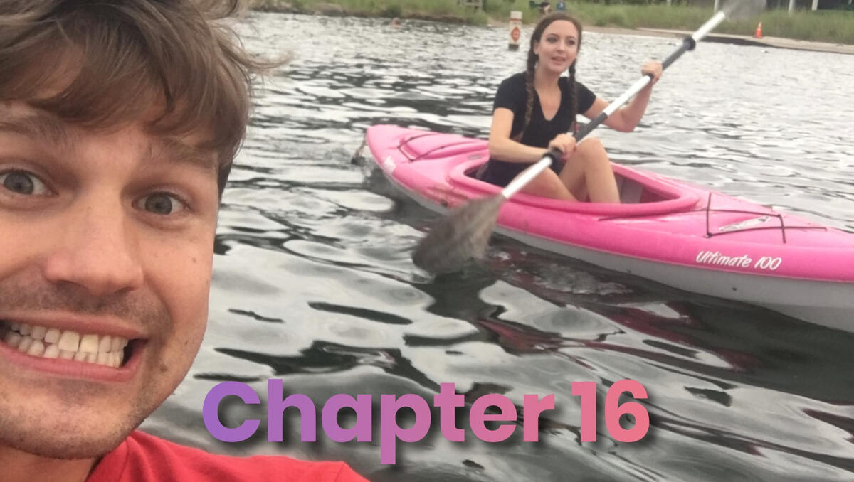 Cute selfie of Damien with Diana kayaking behind him, both smiling